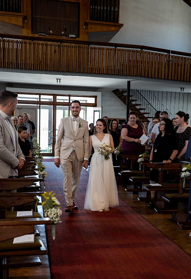 Brautpaar zieht gemeinsam an ihrem Hochzeitstag in die Kirche ein