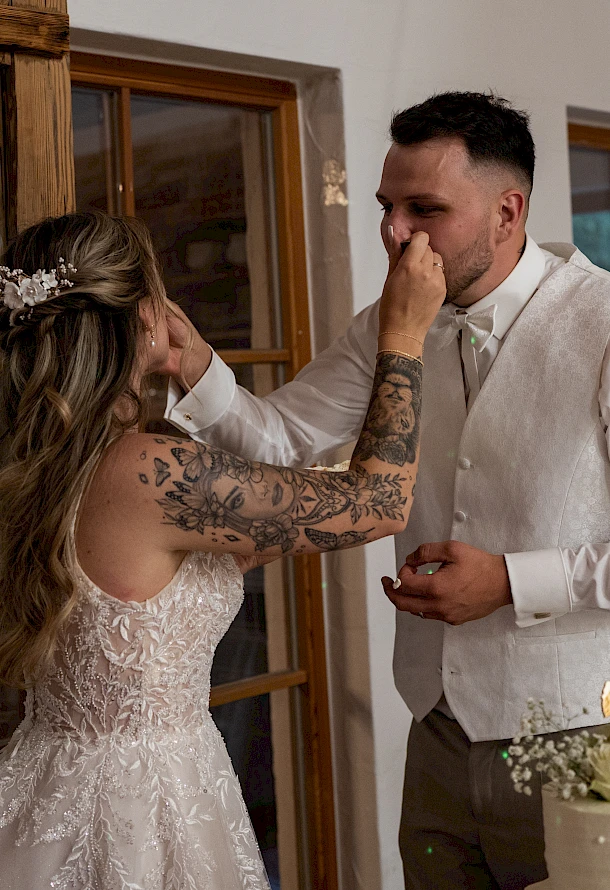Brautpaar feiert seine Hochzeit mit dem traditionellen Anschnitt der Torte