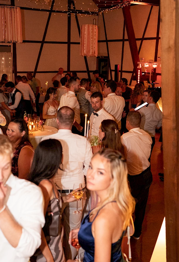Gäste feiern ausgelassen mit dem Brautpaar volle Tanzfläche am Abend in Festscheuen Hermannsfeld